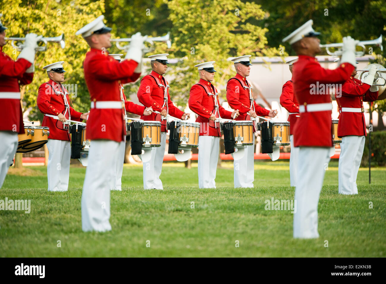 Marines Drum and Bugle corps Sunset Parade Arlington Virginia // ARLINGTON, Virginia — les membres du Marine Drum and Bugle corps, « The commandant's Own », jouent lors de la Sunset Parade au Marine corps War Memorial. L'unité musicale d'élite, créée en 1934, effectue des mouvements de forage de précision tout en jouant de la musique martiale traditionnelle. Le mémorial emblématique, représentant le lever du drapeau à Iwo Jima, sert de toile de fond spectaculaire pour ces cérémonies hebdomadaires d'été qui ont lieu le mardi soir. Les performances mettent en valeur la précision du corps des Marines et l'aspect militaire pour le public de Banque D'Images