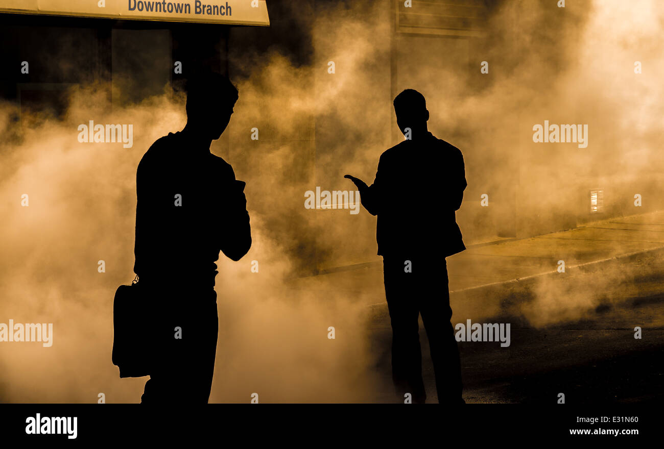 La silhouette de deux personnes debout dans le brouillard. Banque D'Images