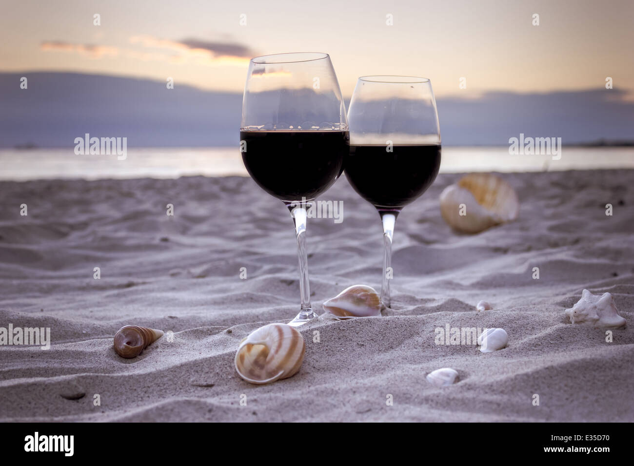 Plage romantique soirée sur le coucher du soleil : deux verres de vin, des bougies, des coquillages, des Valentines Day Banque D'Images