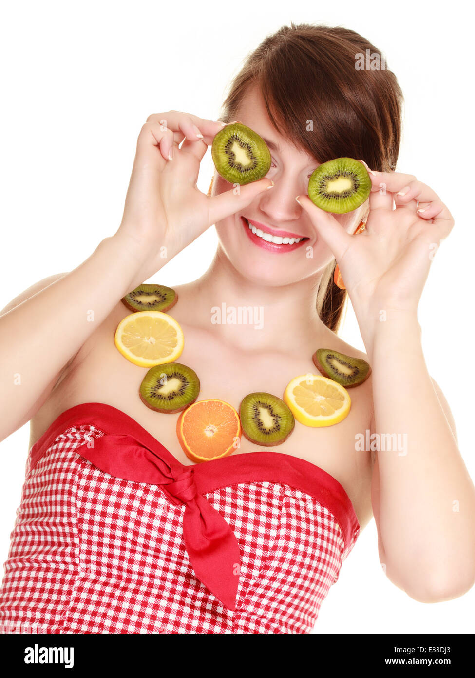 Le régime alimentaire et la nutrition. Femme en collier d'agrumes couvrant les yeux avec des tranches de kiwi isolé sur blanc. Girl doing fun. Banque D'Images