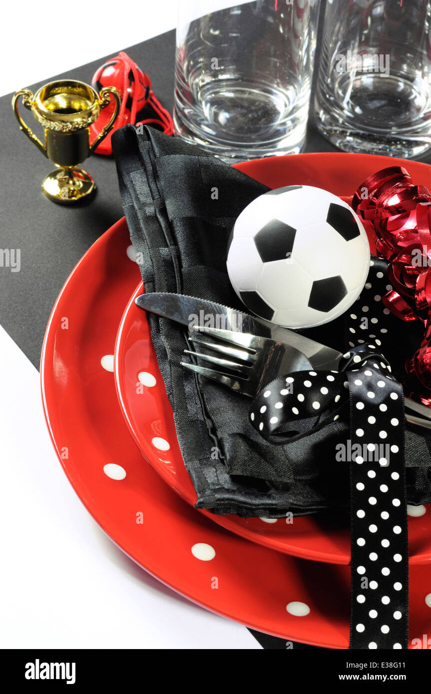 Football Football celebration party table avec pâtés, couverts, verres, trophée, ballon de soccer et de décorations en rouge et noir Banque D'Images