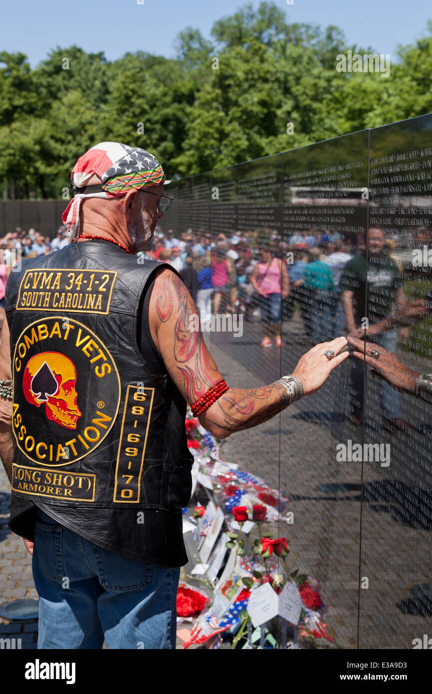Ancien combattant de toucher le mur d'inscrits les noms des soldats tombés au Vietnam Veterans Memorial - Washington, DC USA Banque D'Images