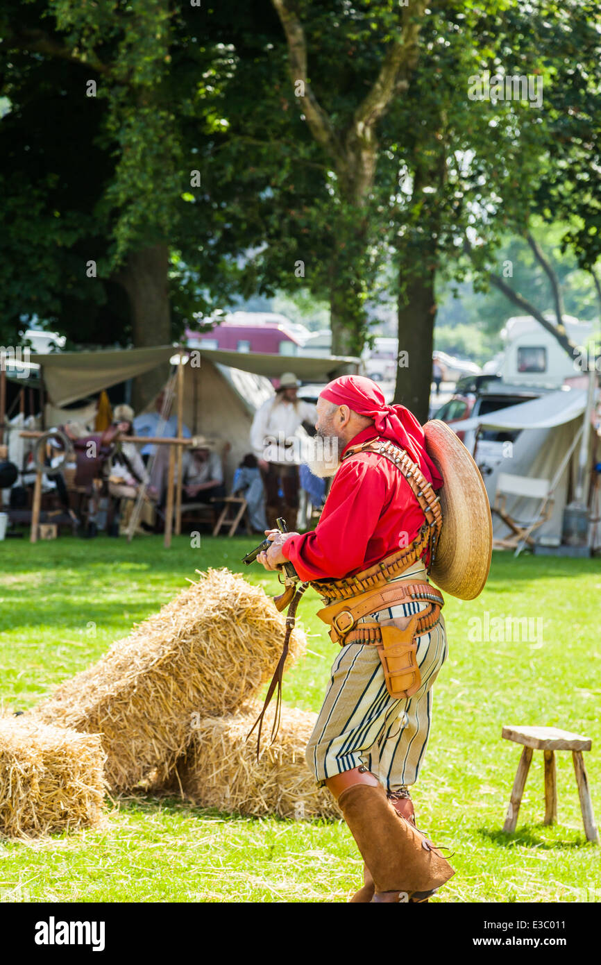 Poireau, Staffordshire, Angleterre. 22 juin 2014, un week-end country et western. Un méchant Cowboy menace les populations à canon tiré. Banque D'Images