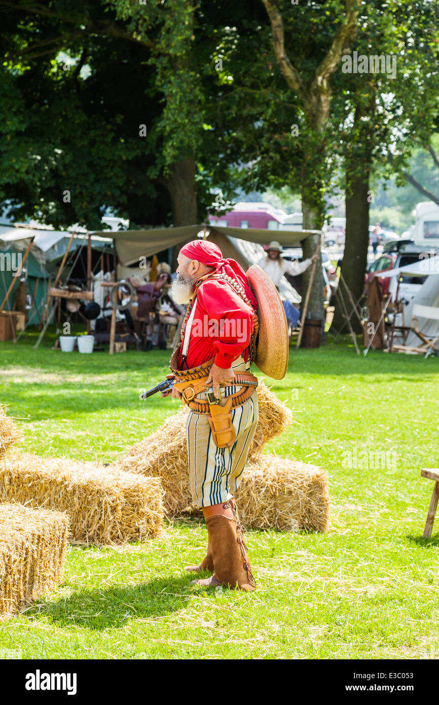 Poireau, Staffordshire, Angleterre. 22 juin 2014, un week-end country et western. Un méchant Cowboy menace les populations à canon tiré. Banque D'Images