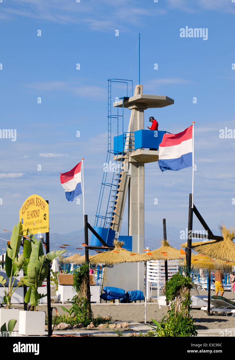 Plus d'un tour de béton lifeguard plage méditerranéenne ensoleillée, avec drapeaux néerlandais. Torremolinos, Andalousie, espagne. Banque D'Images