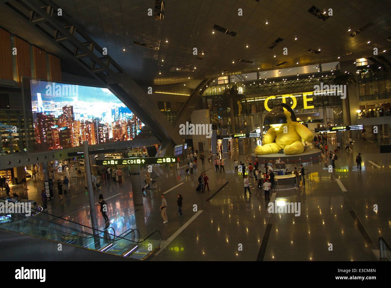 Doha, Qatar, 22 juin, 2014. Les passagers vu marcher dans le hall de l'Aéroport International Hamad nouveau (IHA) à Doha, par l'installation de l'ours de la lampe par l'artiste des téé Urs Fisher. Crédit : David Mbiyu/ Alamy Live News © David mbiyu/Alamy Live News Banque D'Images