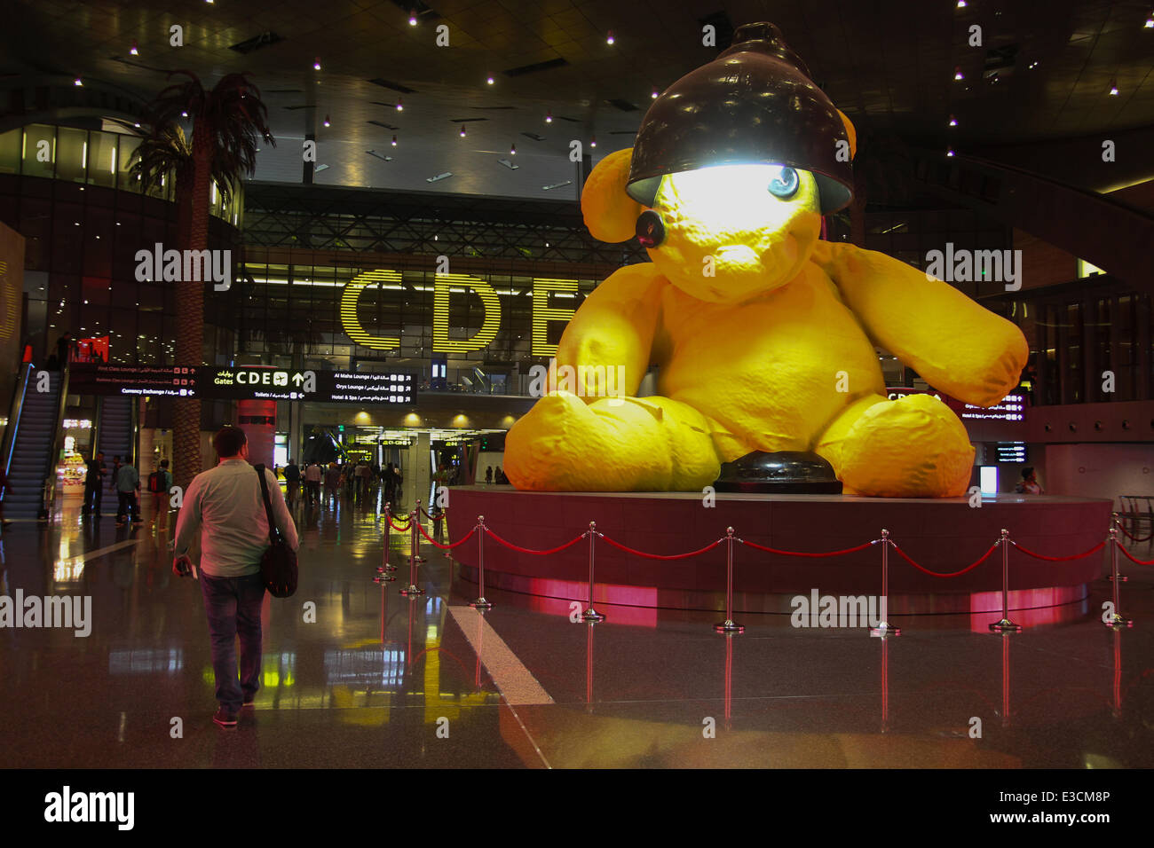 Doha, Qatar, 22 juin, 2014. Un passager vu en passant devant la porte de la lampe par l'installation de l'artiste suisse Urs Fisher dans le hall de l'Aéroport International Hamad nouvellement ouvert (IHA) à Doha. Crédit : David Mbiyu/ Alamy Live News © David mbiyu/Alamy Live News Banque D'Images