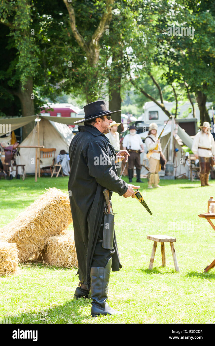 Poireau, Staffordshire, Angleterre. 22 juin 2014, un week-end country et western. Cowboy vêtu de noir l'arme au poing. Banque D'Images