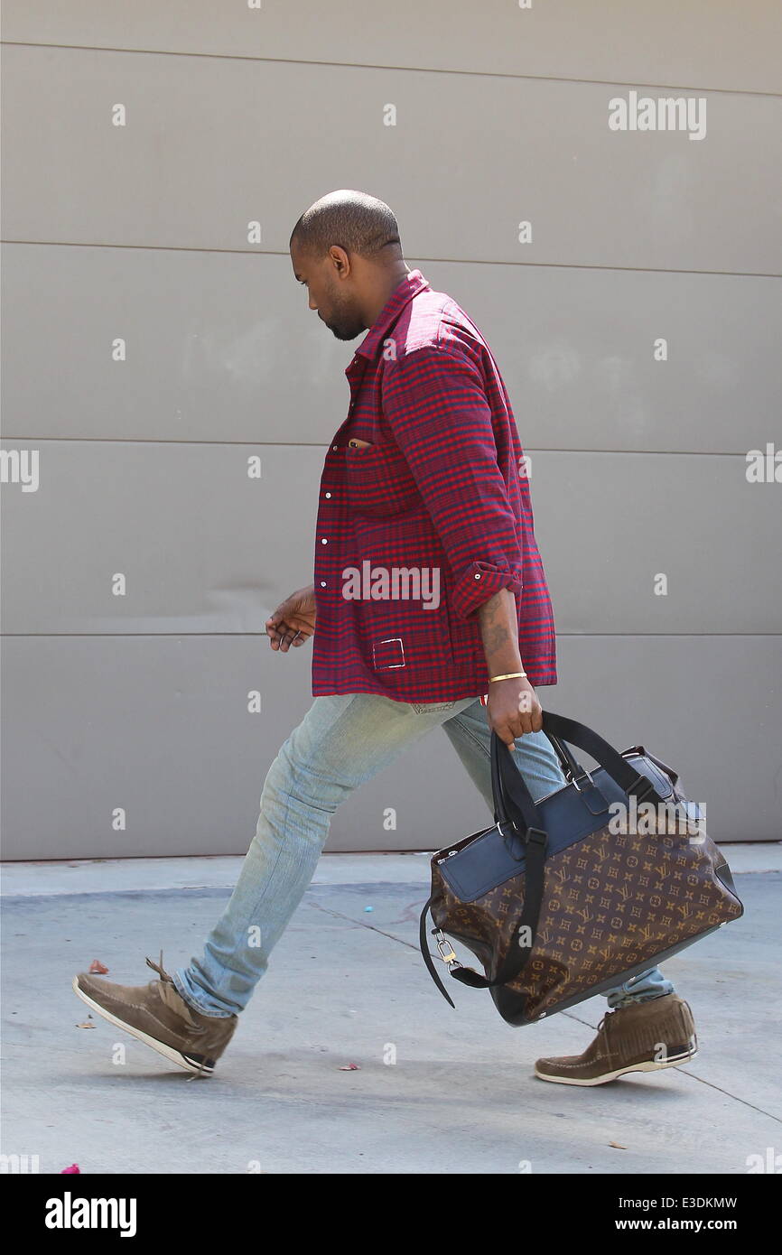 Kanye West de quitter son bureau dans une veste à carreaux rouge et bleu et  portant un grand sac Louis Vuitton bagages comprend : Kany Photo Stock -  Alamy
