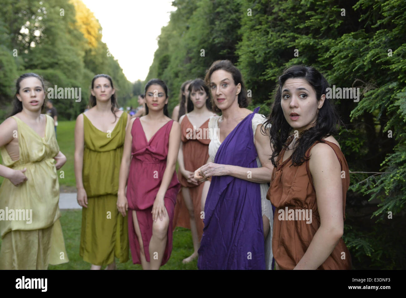 Old Westbury, New York, USA. 21 Juin, 2014. Lori Belilove & l'Isadora Duncan Dance Company sont en attente dans le sud allée, une allée bordée de conifères, peu avant l'danseurs modernes se produira le Songe d'une nuit finale de l'événement à la Long Island Gold Coast estate de Old Westbury Gardens le premier jour de l'été, le solstice d'été. Mme Belilove porte une tunique blanche avec plus de violet-écharpe. © Ann Parry/ZUMA/ZUMAPRESS.com/Alamy fil Live News Banque D'Images