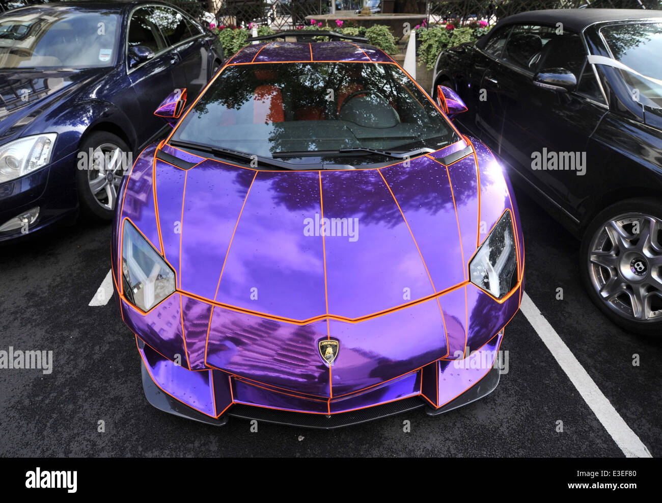 Les passants s'arrêter pour vérifier deux voitures flashy garé à l'extérieur de la face de l'Hôtel Dorchester. Une Lamborghini Aventador violet et jaune et or Bugatti Veyron. En vedette : Lamborghini Aventador Où : London, Royaume-Uni Quand : 20 Oct 2013 Banque D'Images