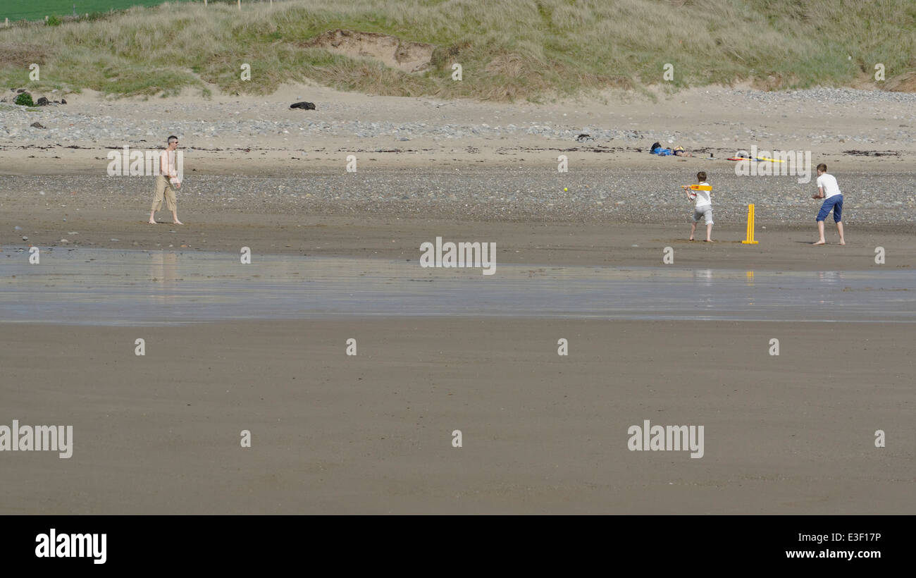 Un père jouer au cricket sur la plage avec ses fils Banque D'Images