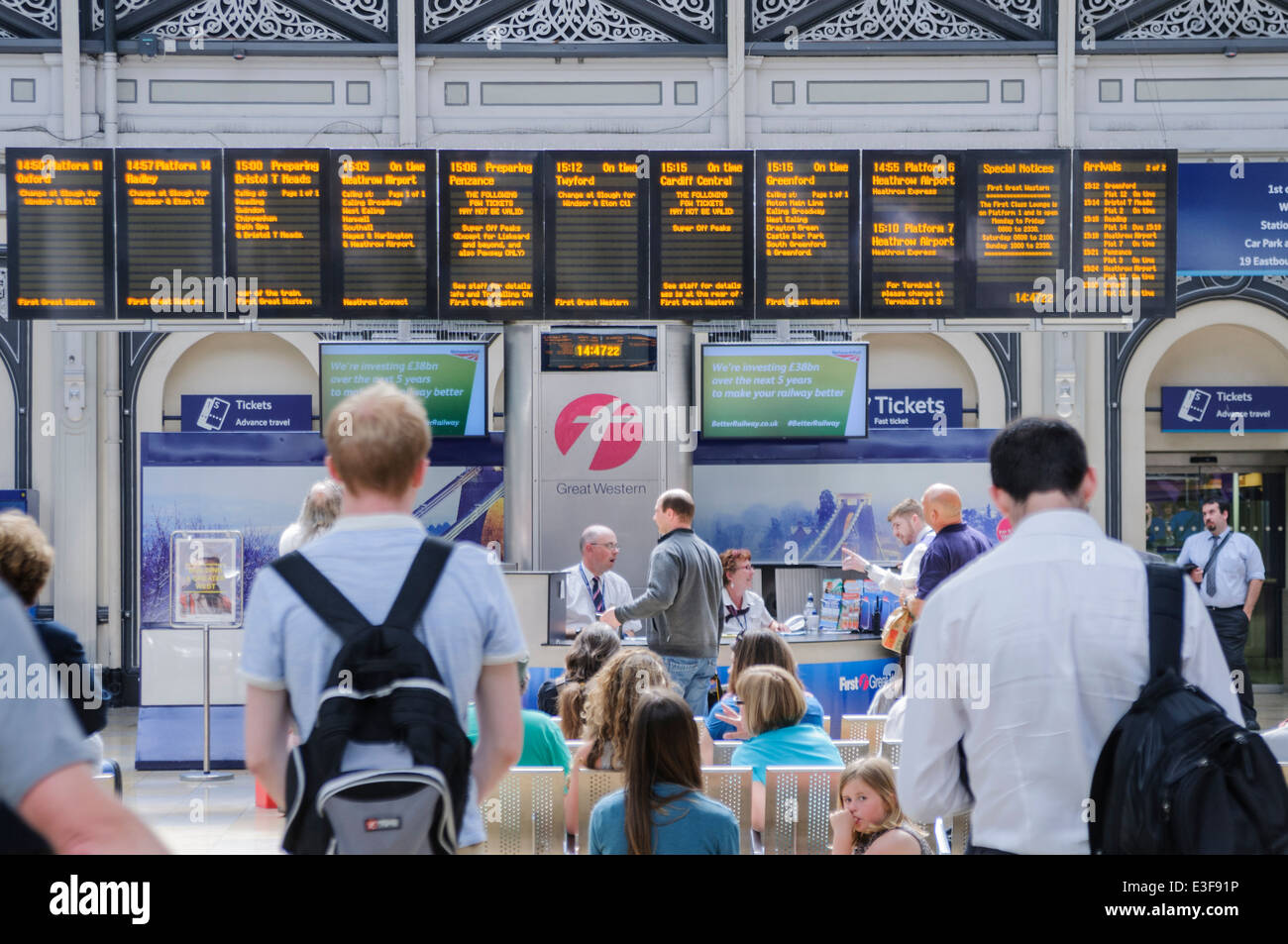 Les banlieusards regarder les horaires sur les panneaux à la gare de Paddington. Banque D'Images