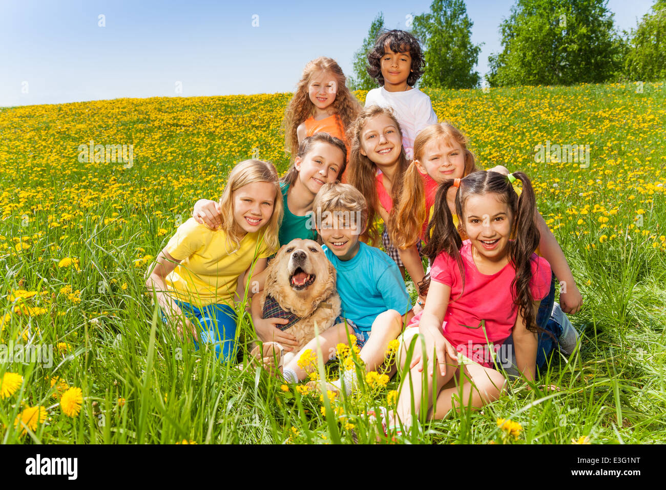 Happy kids avec chien assis sur l'herbe Banque D'Images