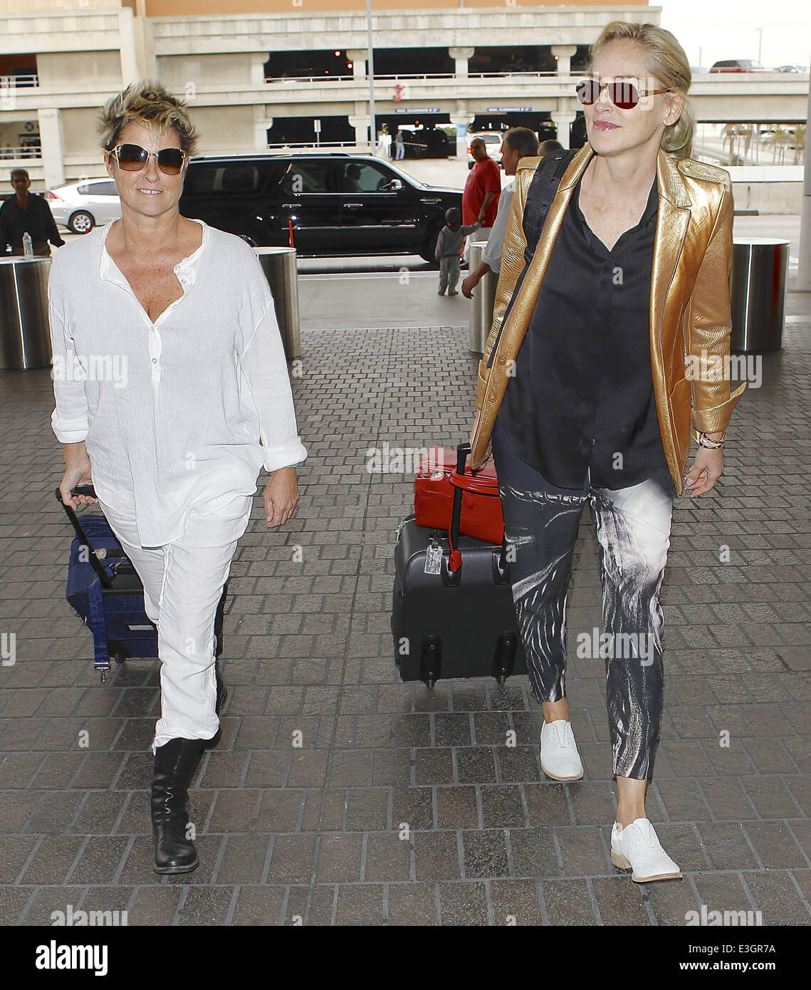 Basic Instinct' L'actrice Sharon Stone s'écarte de LAX avec un ami, vêtu  d'une veste de couleur cuivre, pantalon imprimé blanc et chaussures. Avec :  Sharon Stone Où : Los Angeles, California, United