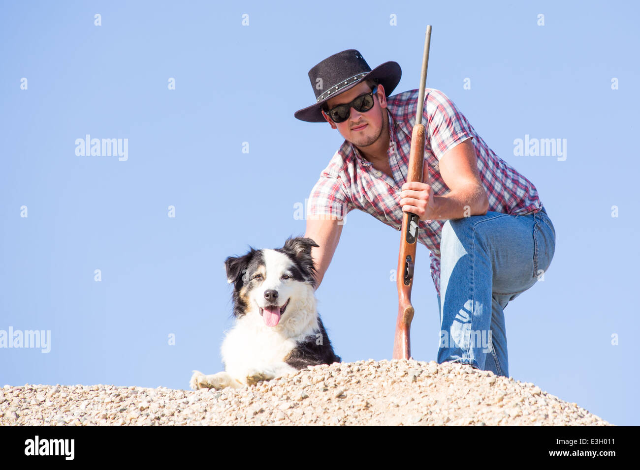 Un jeune agriculteur avec son fusil et chien à l'affût des coyotes que tuer ses animaux Banque D'Images