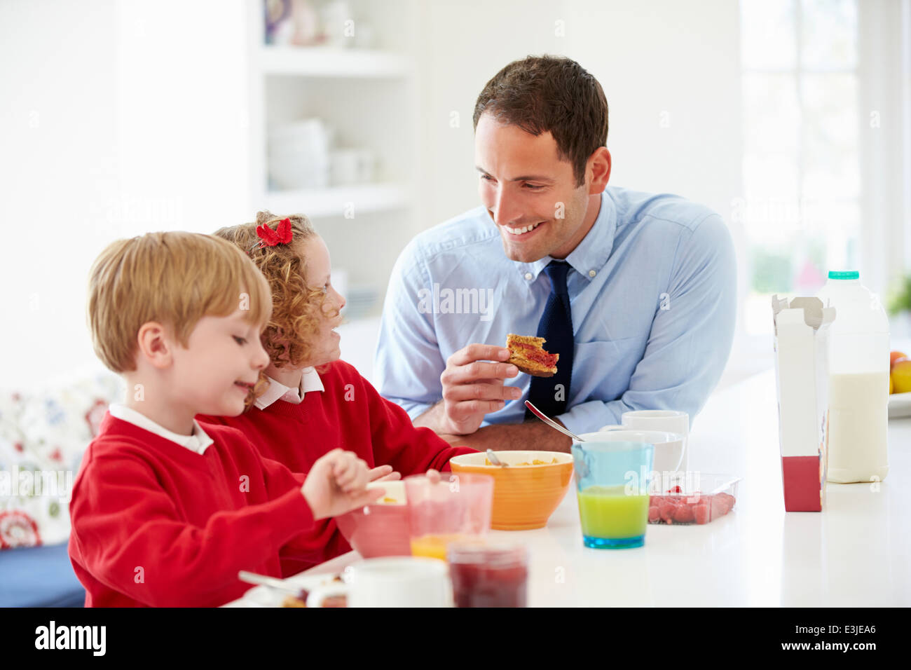 Le père et les enfants de prendre le petit déjeuner dans la cuisine ensemble Banque D'Images