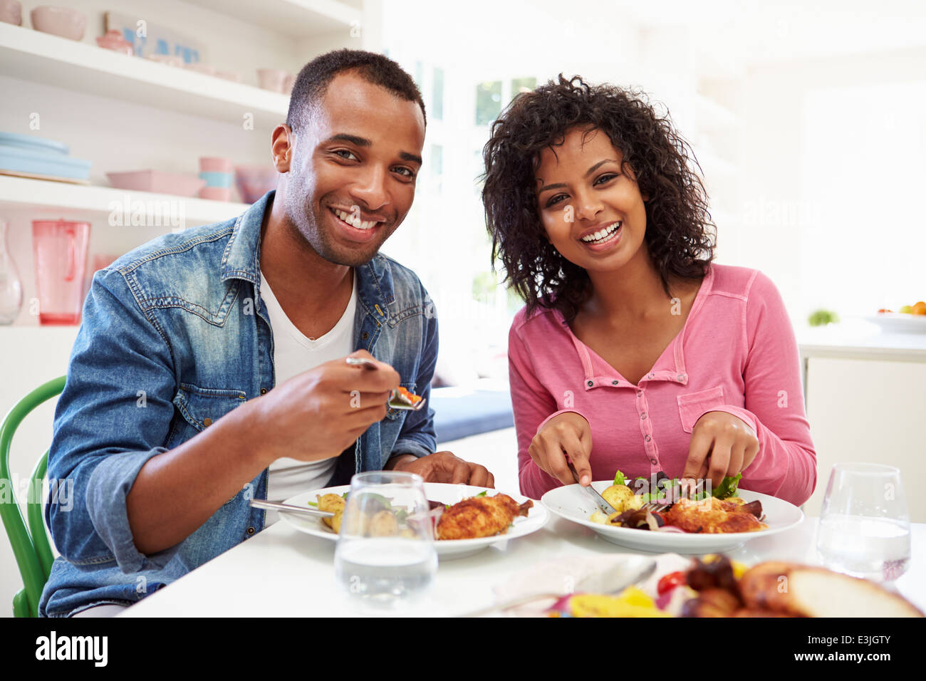Young African American Couple Eating Meal At Home Banque D'Images