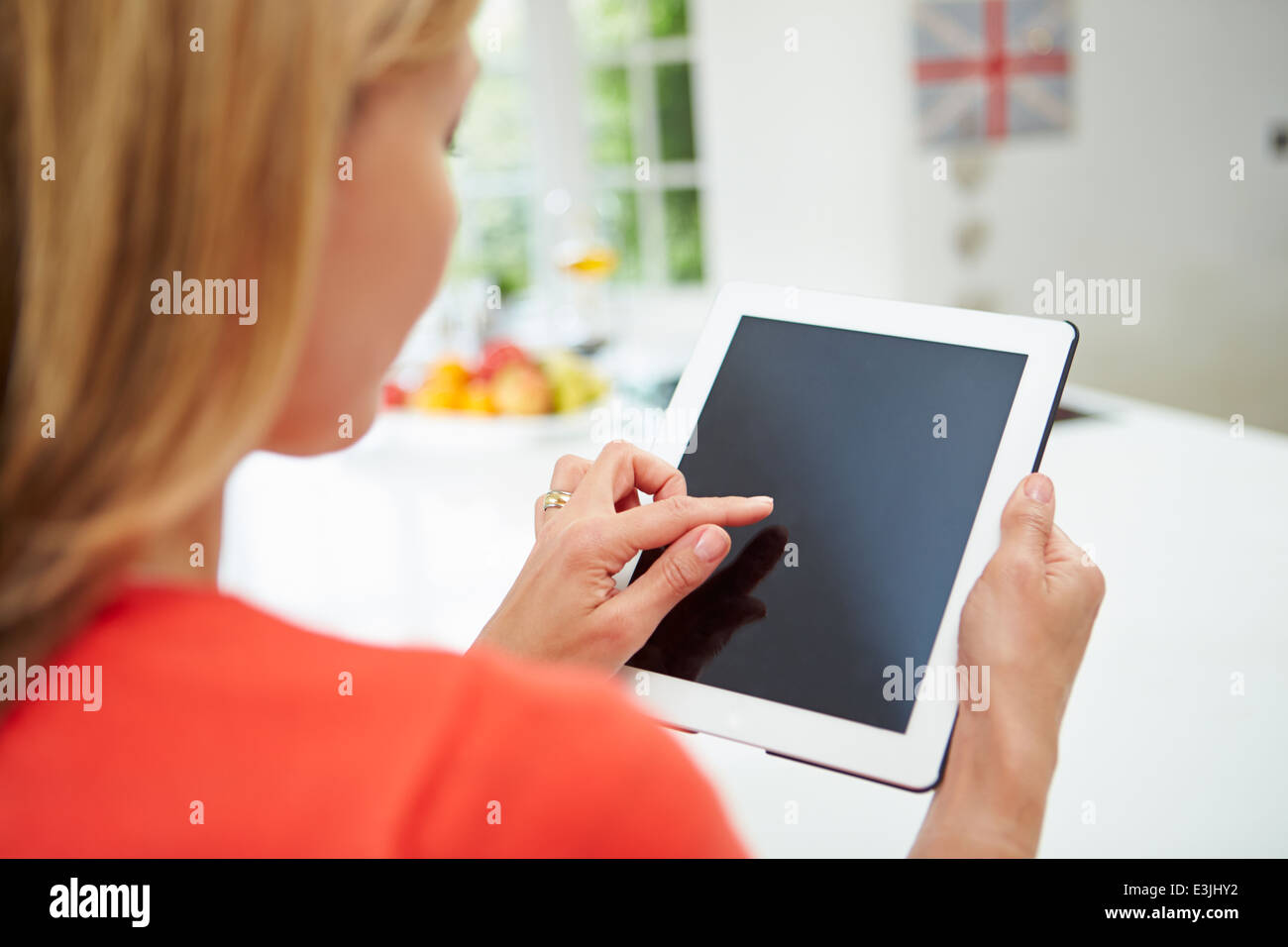 Woman Using Digital Tablet In Kitchen Banque D'Images
