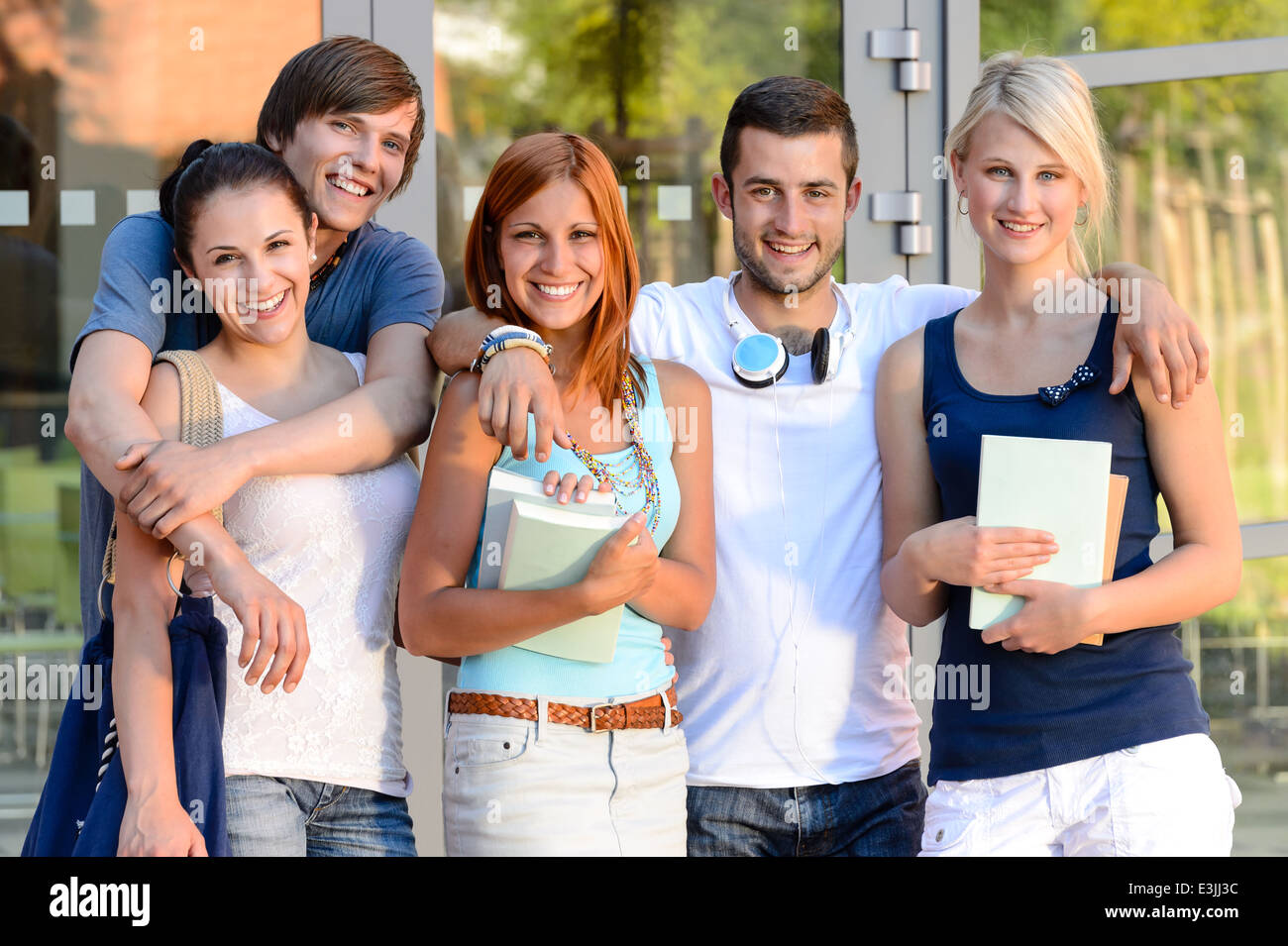 Group of smiling students standing face de campus d'été Banque D'Images