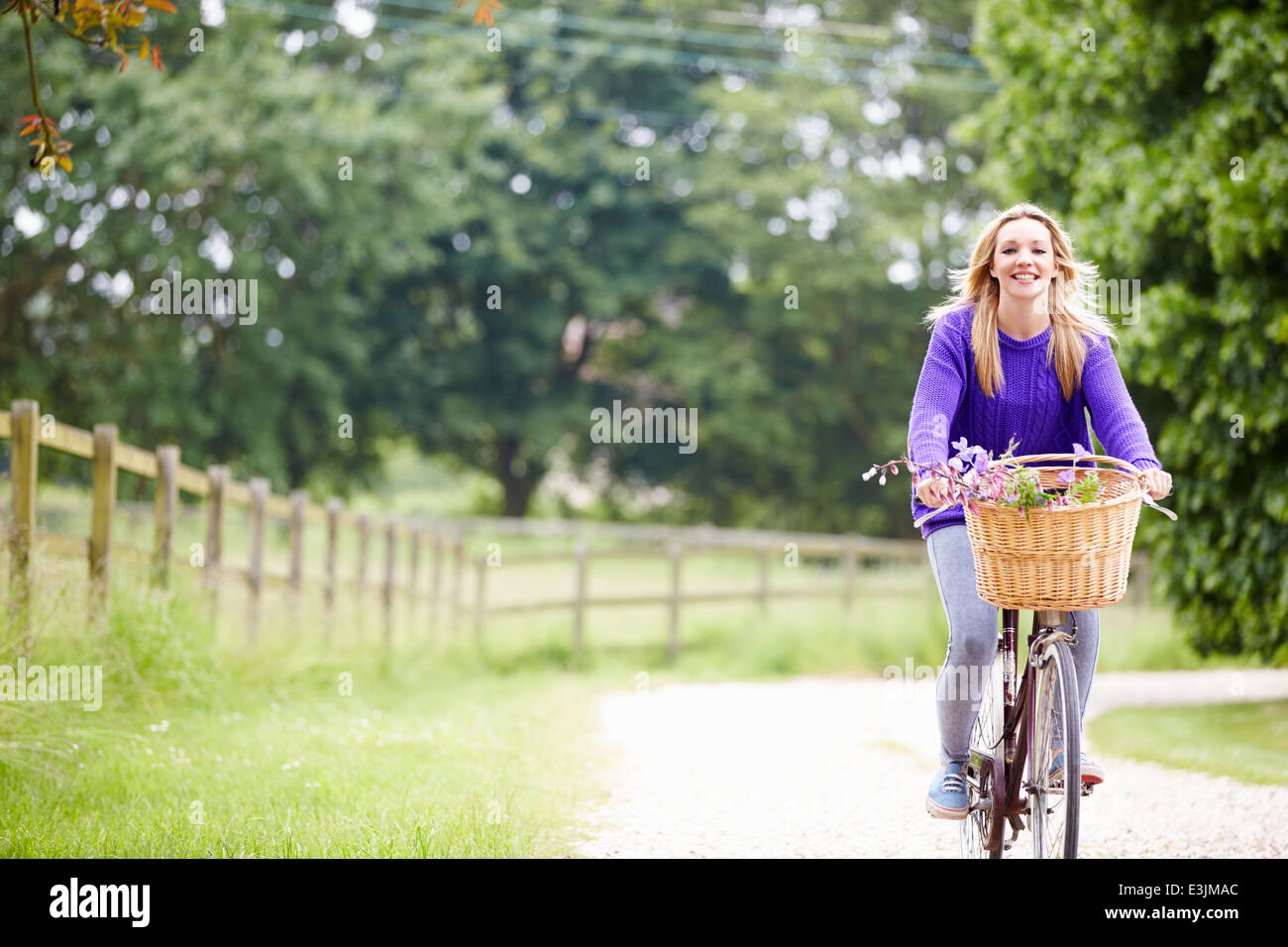 Teenage Girl Riding Bike le long chemin de campagne Banque D'Images
