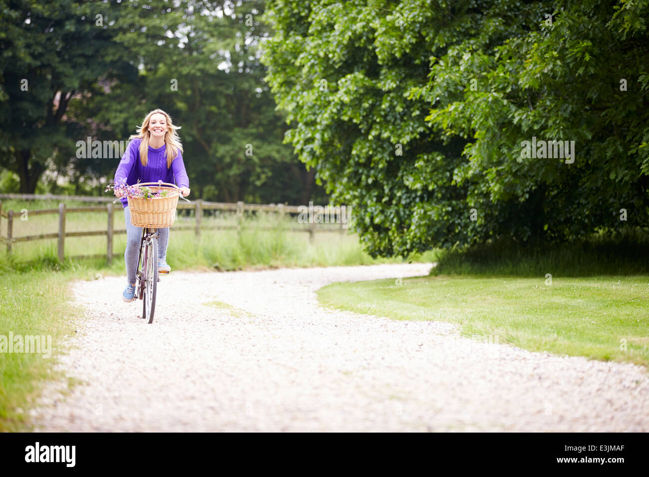 Teenage Girl Riding Bike le long chemin de campagne Banque D'Images