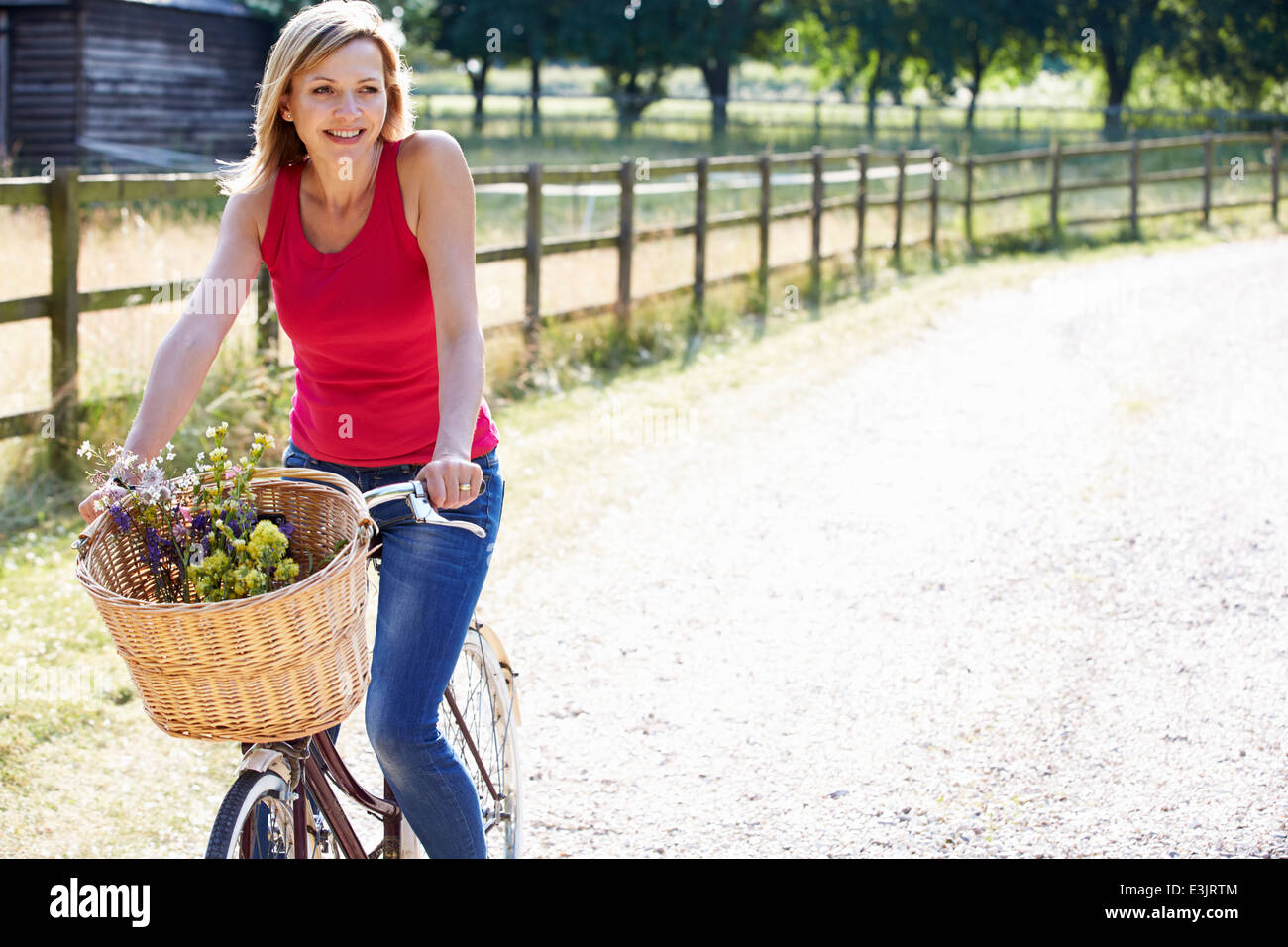 Attractive Woman Riding Bike le long chemin de campagne Banque D'Images