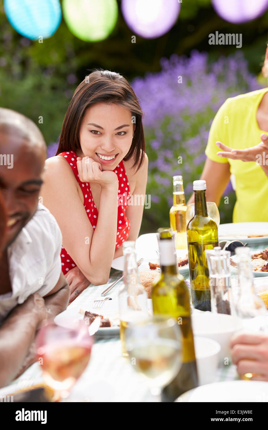 Young Woman Relaxing At Outdoor Barbeque Banque D'Images