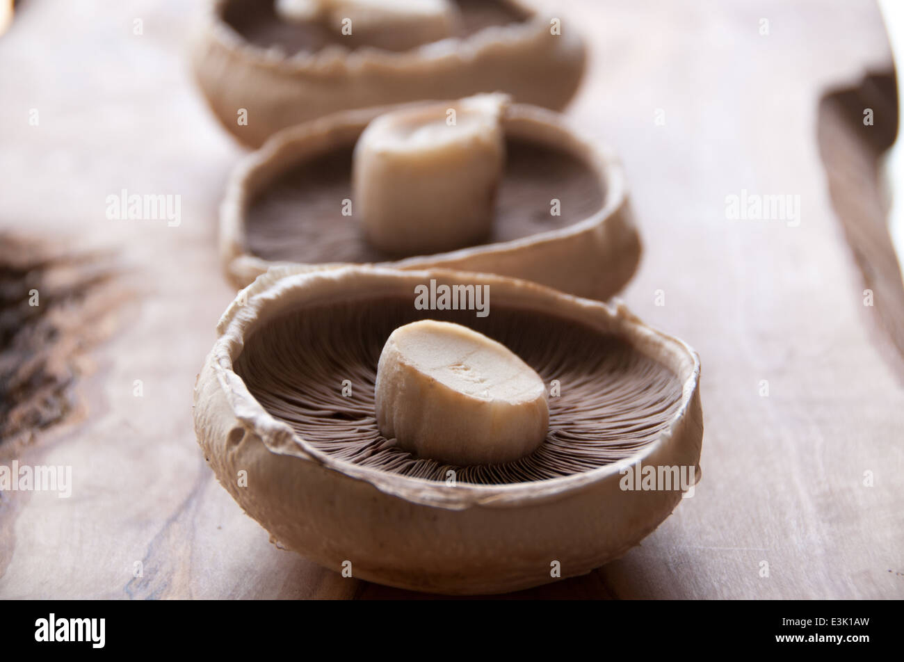 Trois champignons portobello rustique sur une planche à découper Banque D'Images