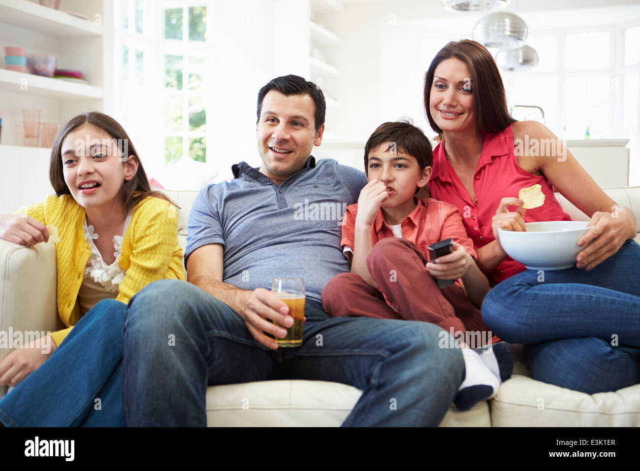 Hispanic Family Sitting on Sofa à regarder la télévision ensemble Banque D'Images