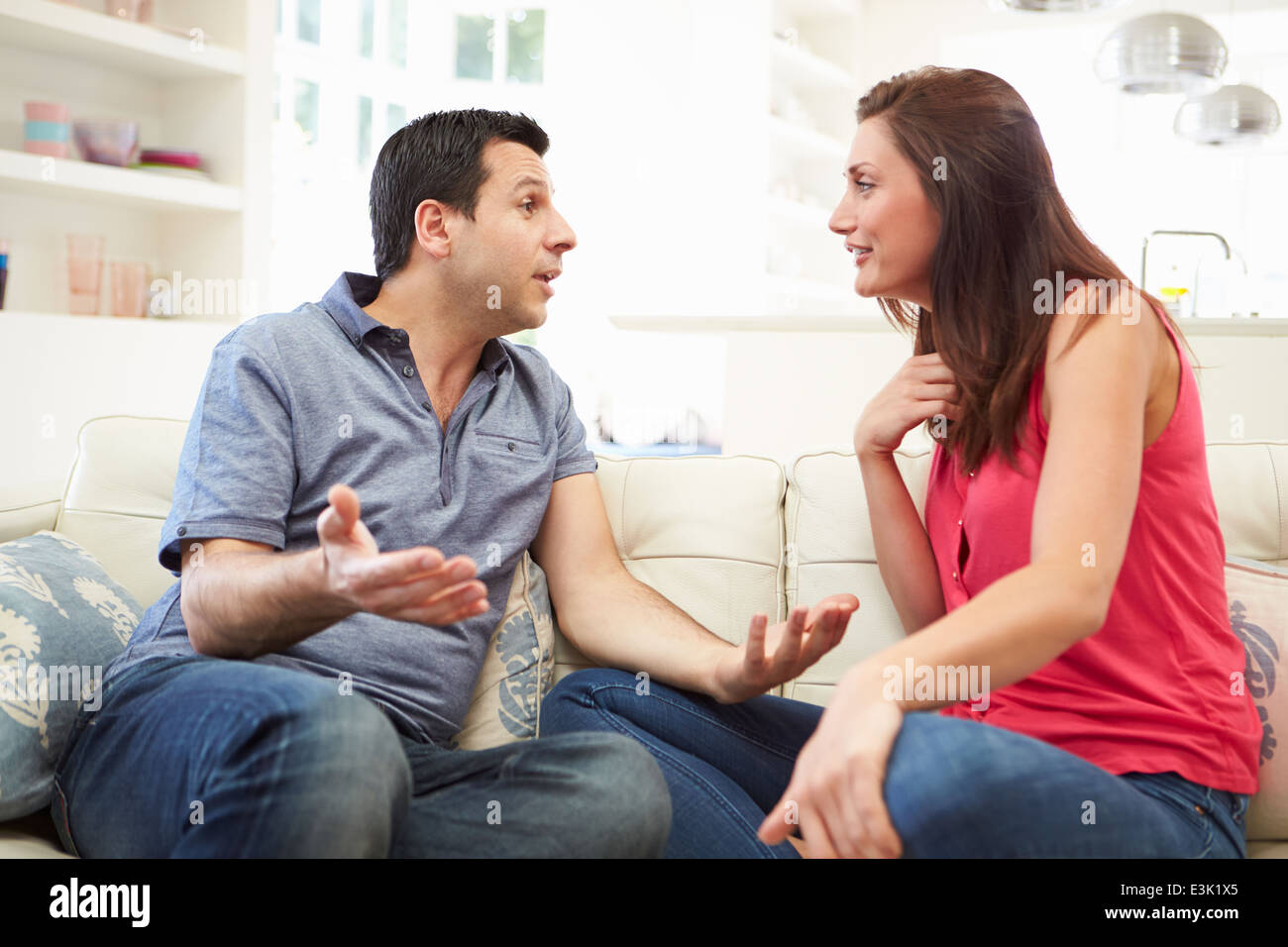 Hispanic Couple Sitting on Sofa arguant Banque D'Images