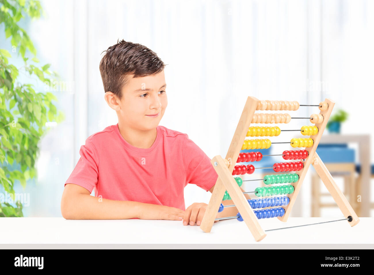 Kid compte sur un boulier assis sur table à la maison Banque D'Images