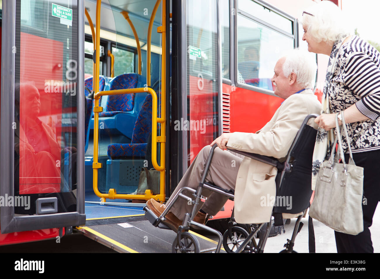 Bus d'embarquement Couple à l'aide de rampe d'accès pour fauteuil roulant Banque D'Images