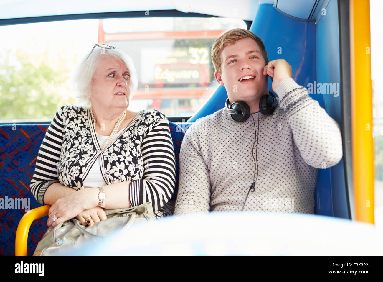 Homme inquiétant les passagers des bus avec appel téléphonique Banque D'Images