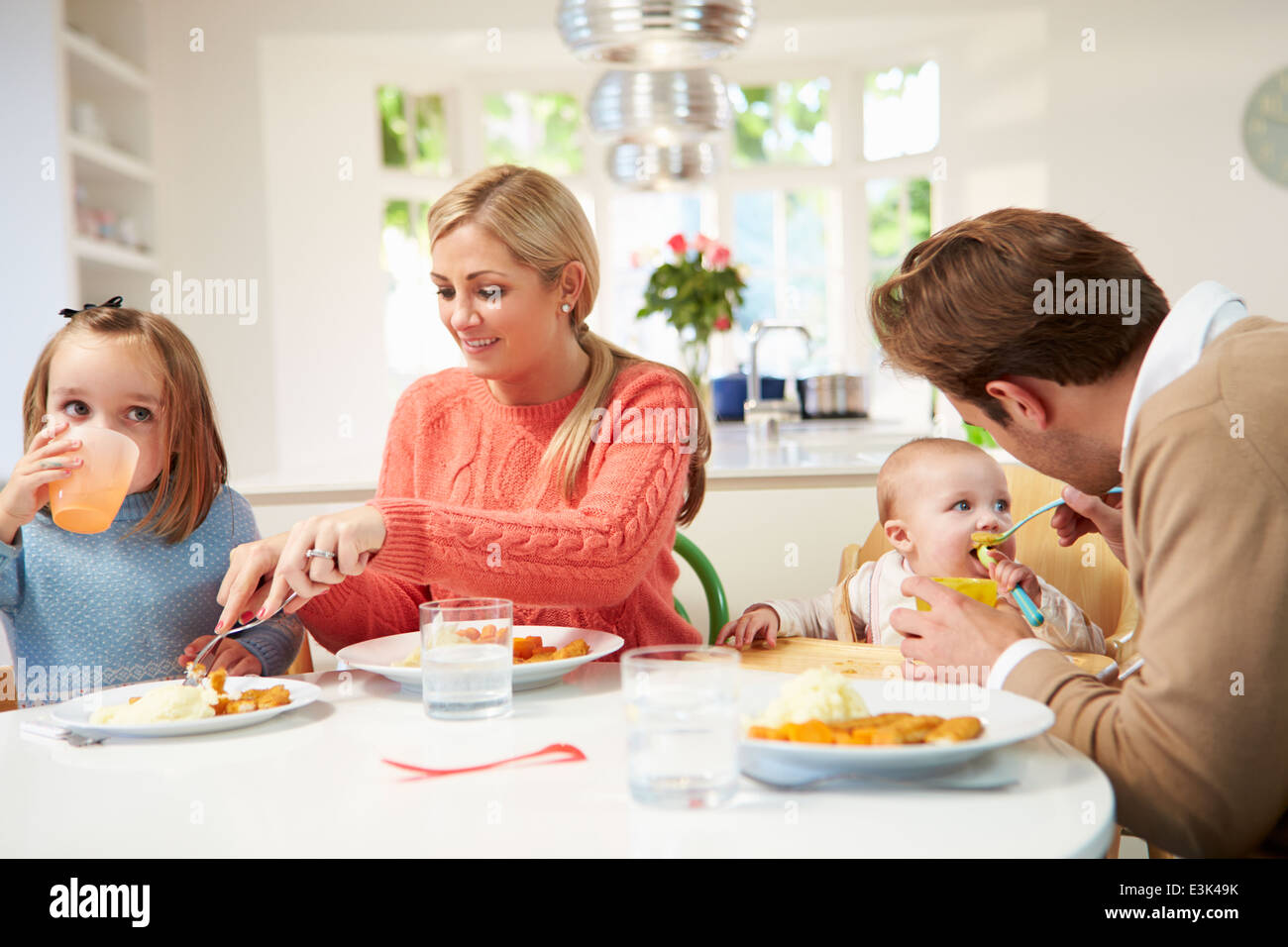 Famille avec jeunes Baby Eating Meal At Home Banque D'Images