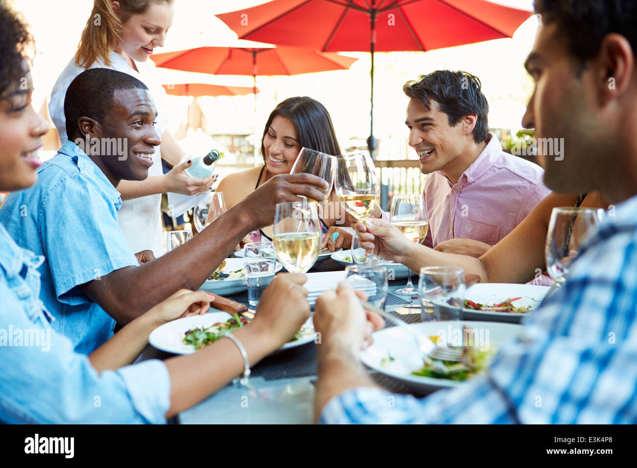 Group of Friends Enjoying Meal At Outdoor Restaurant Banque D'Images
