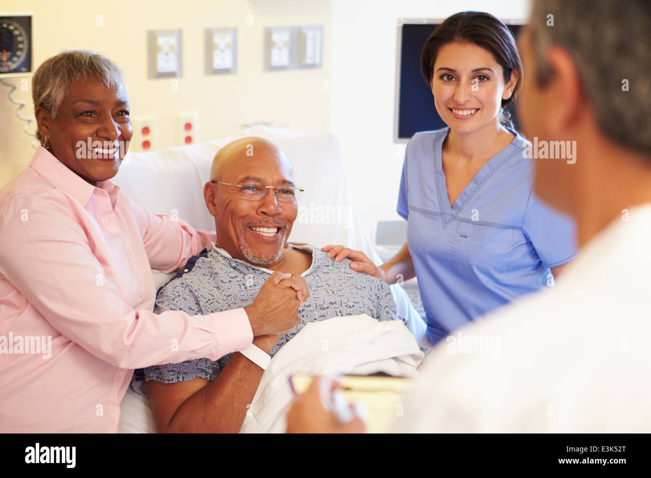 Rencontre avec l'équipe médicale Senior Couple in Hospital Room Banque D'Images