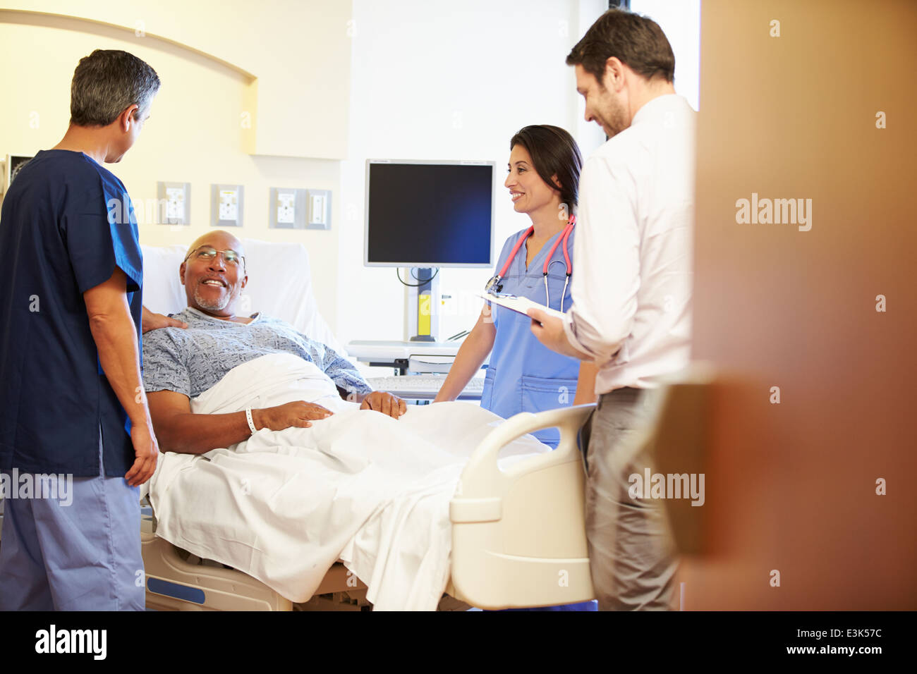 Rencontre avec l'équipe médicale Senior Man In Hospital Room Banque D'Images