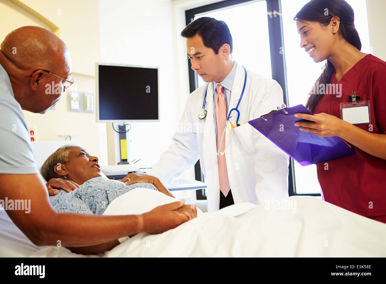 Rencontre avec l'équipe médicale Senior Couple in Hospital Room Banque D'Images