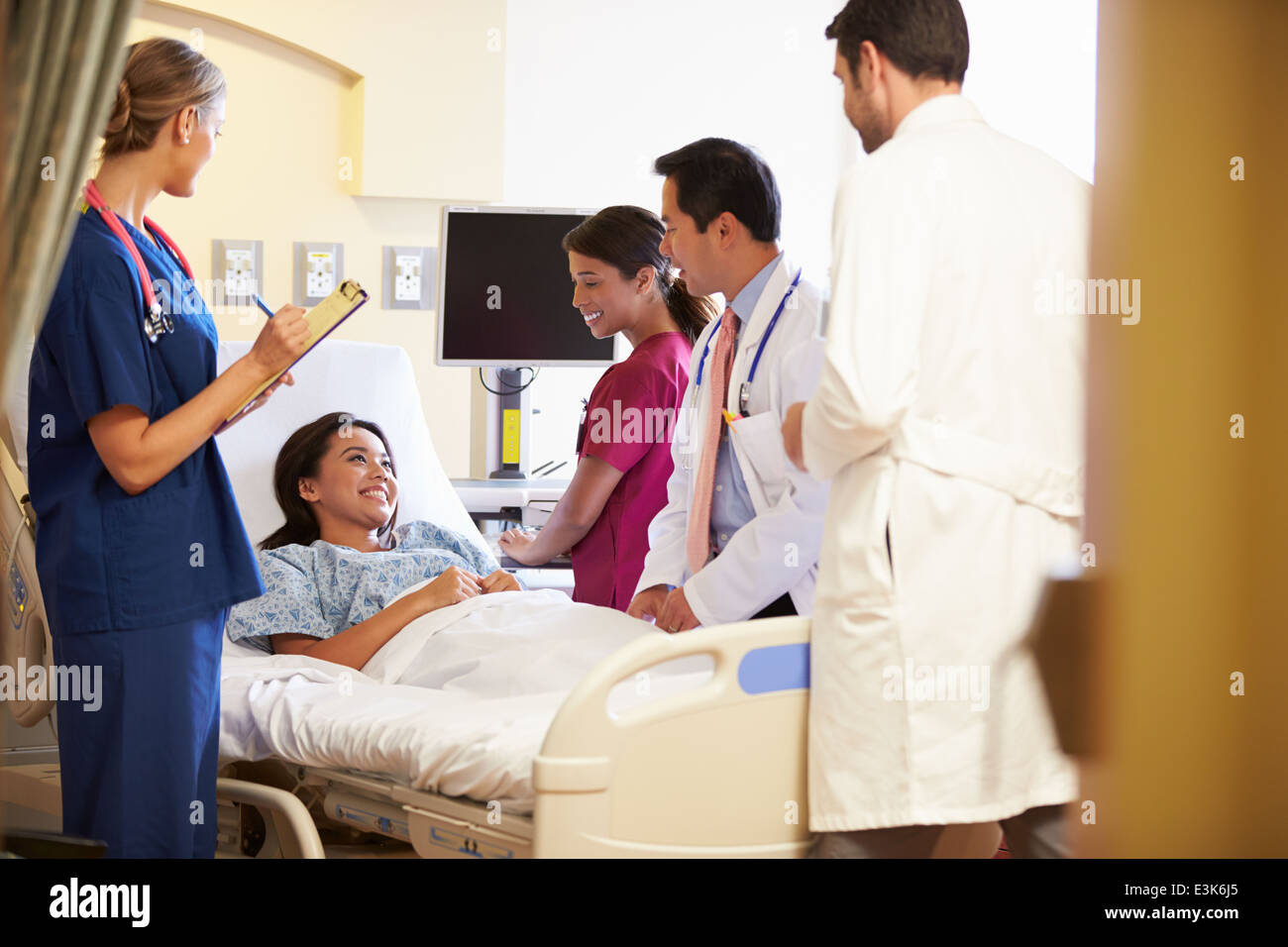 Réunion de l'équipe médicale autour de Female Patient In Hospital Room Banque D'Images