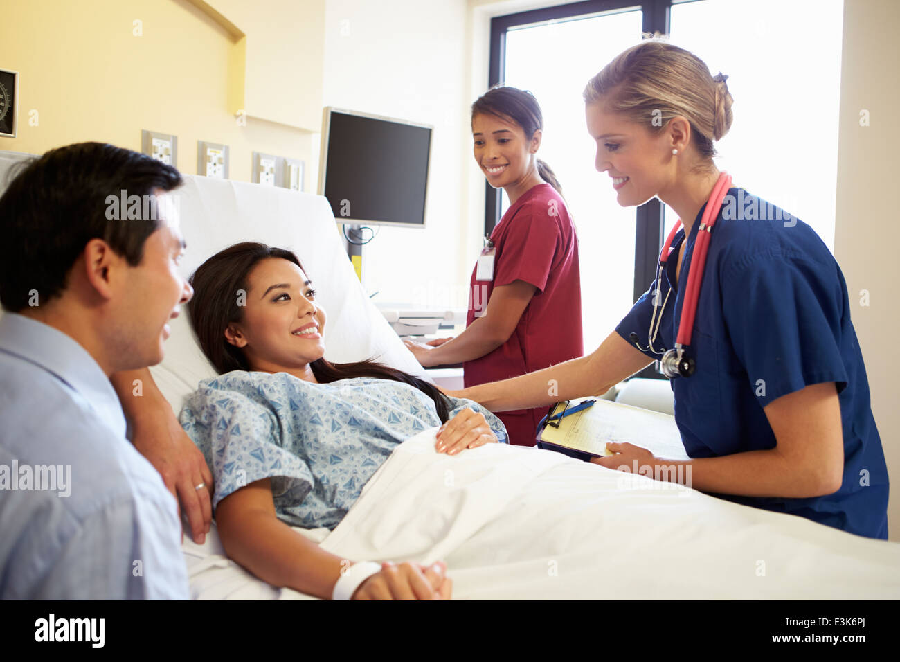 L'équipe médicale Rencontre avec couple In Hospital Room Banque D'Images