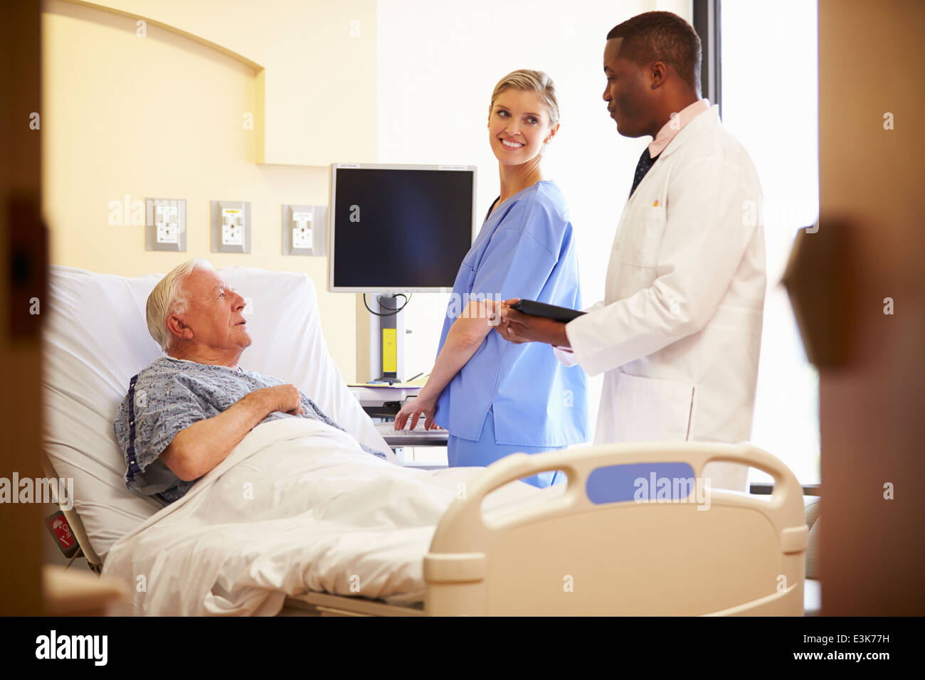 Rencontre avec l'équipe médicale Senior Man In Hospital Room Banque D'Images