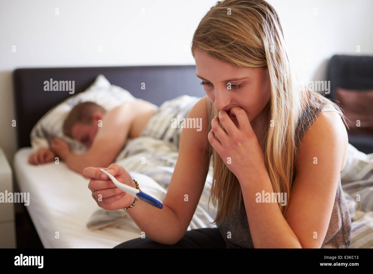 Peur adolescente dans chambre avec kit de test de grossesse Banque D'Images
