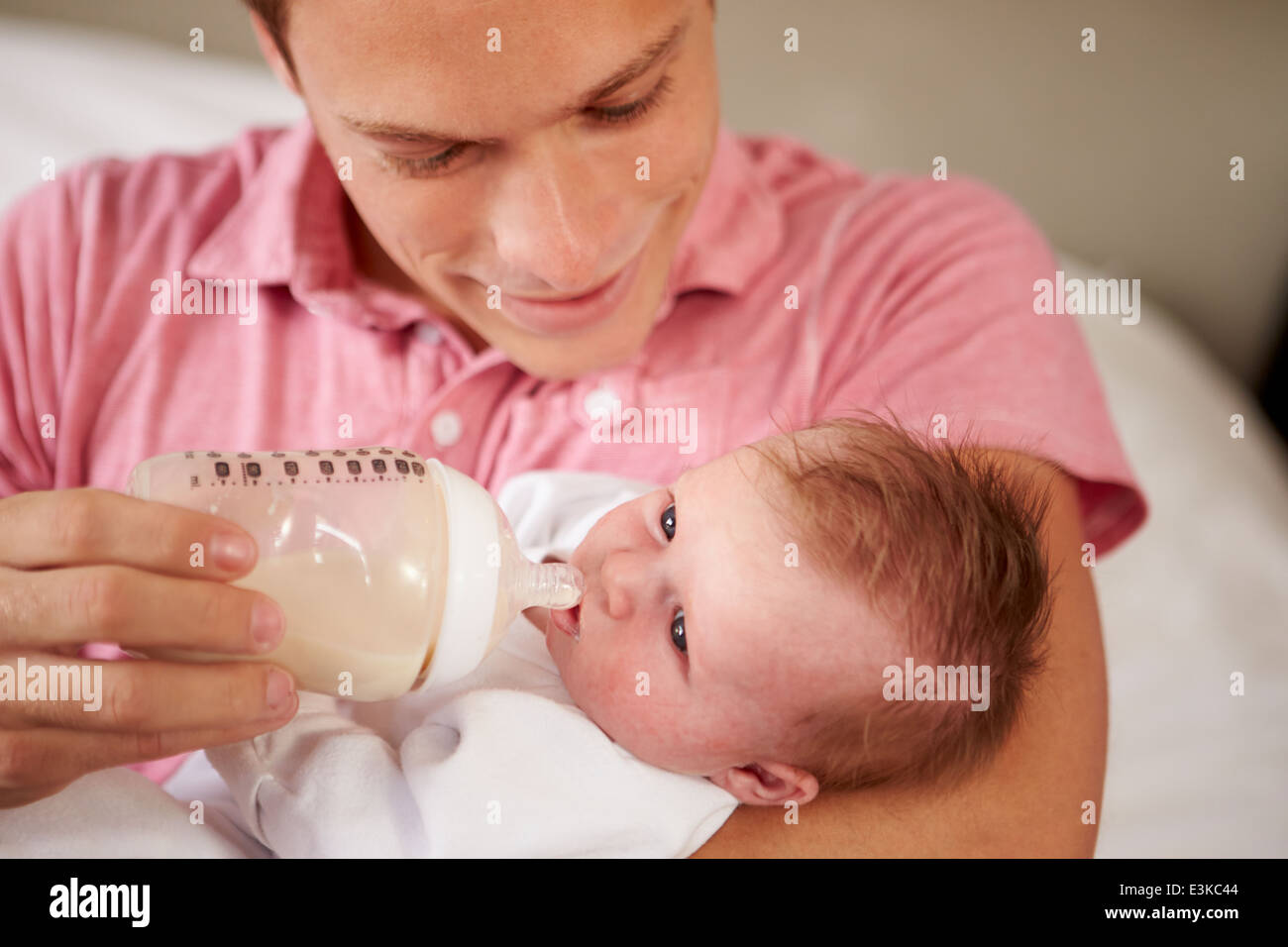 Père de donner sa petite fille bouteille de lait Banque D'Images