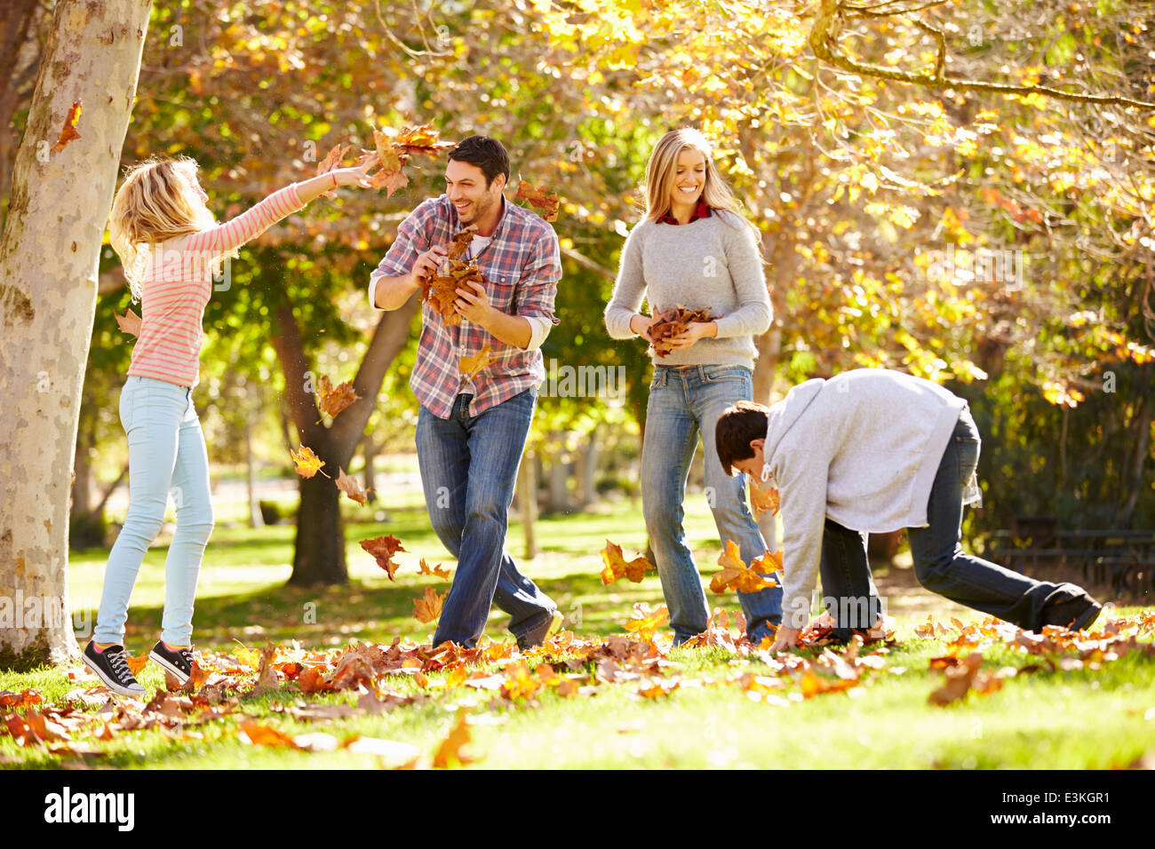 Jeter les feuilles d'automne de la famille dans l'air Banque D'Images