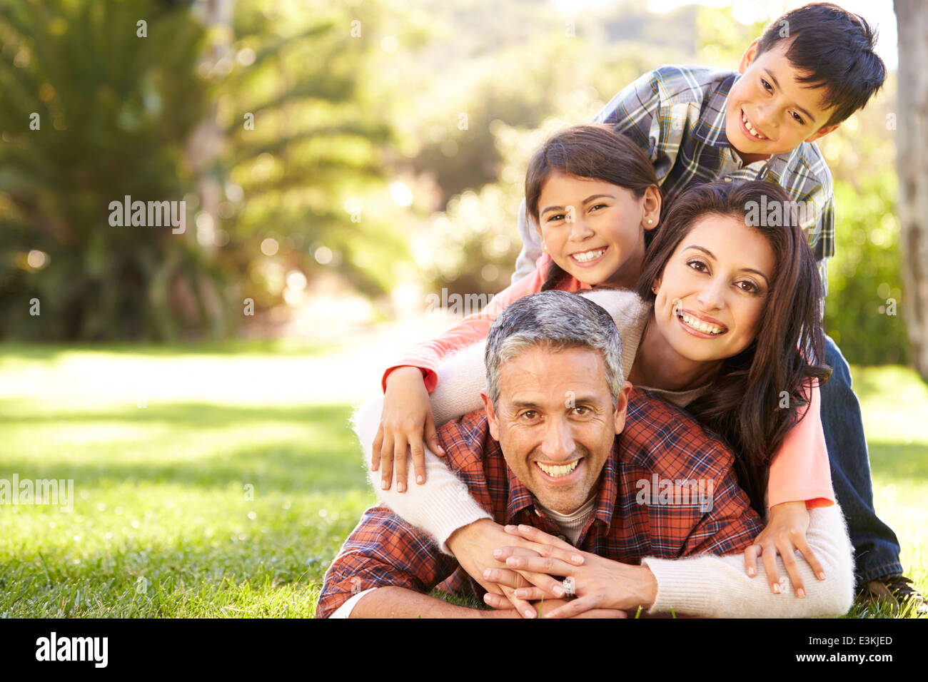 Portrait Of Family Lying On Grass In Countryside Banque D'Images