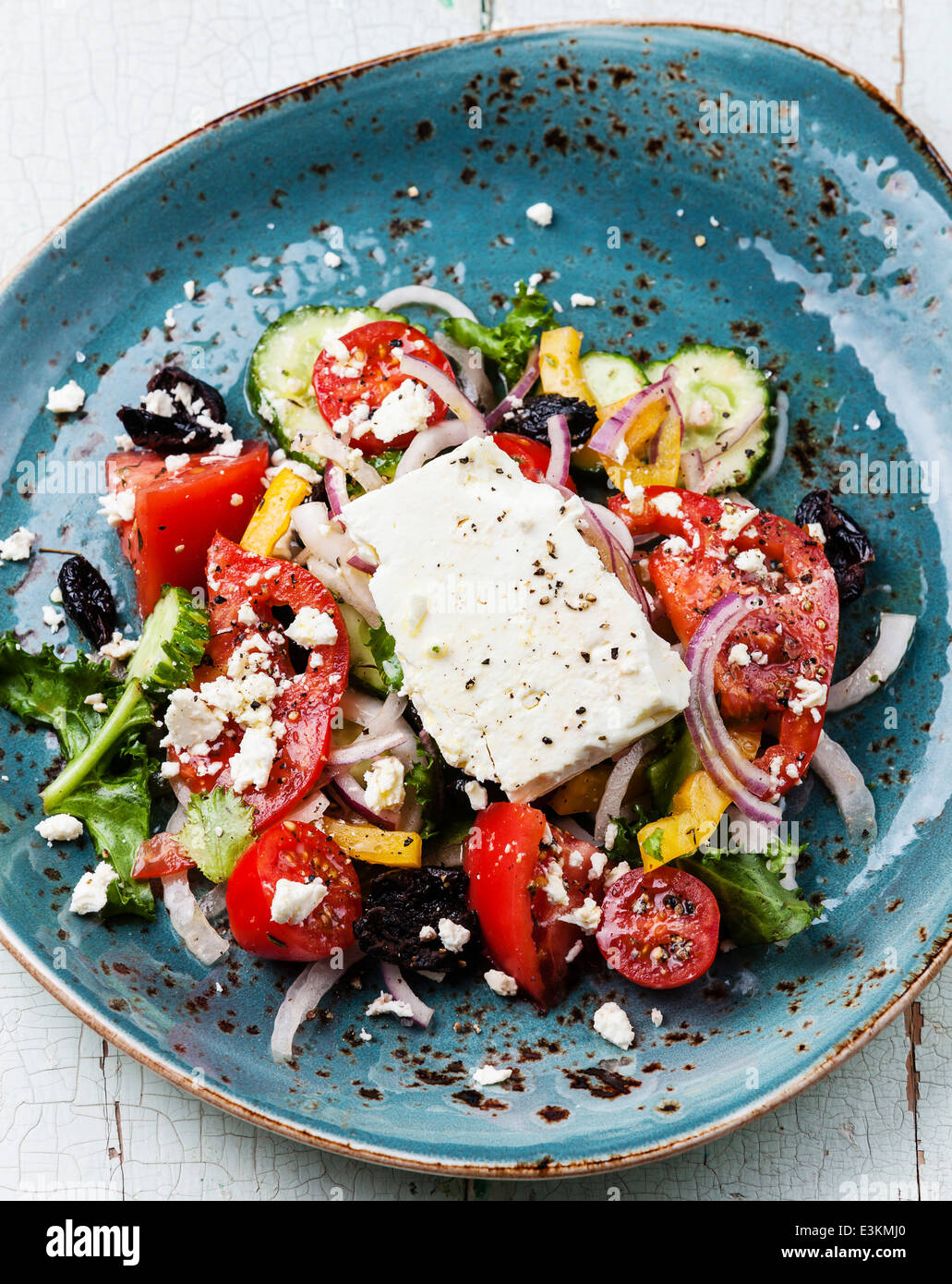 Salade grecque avec feta et olives séchées au soleil sur fond bleu Banque D'Images