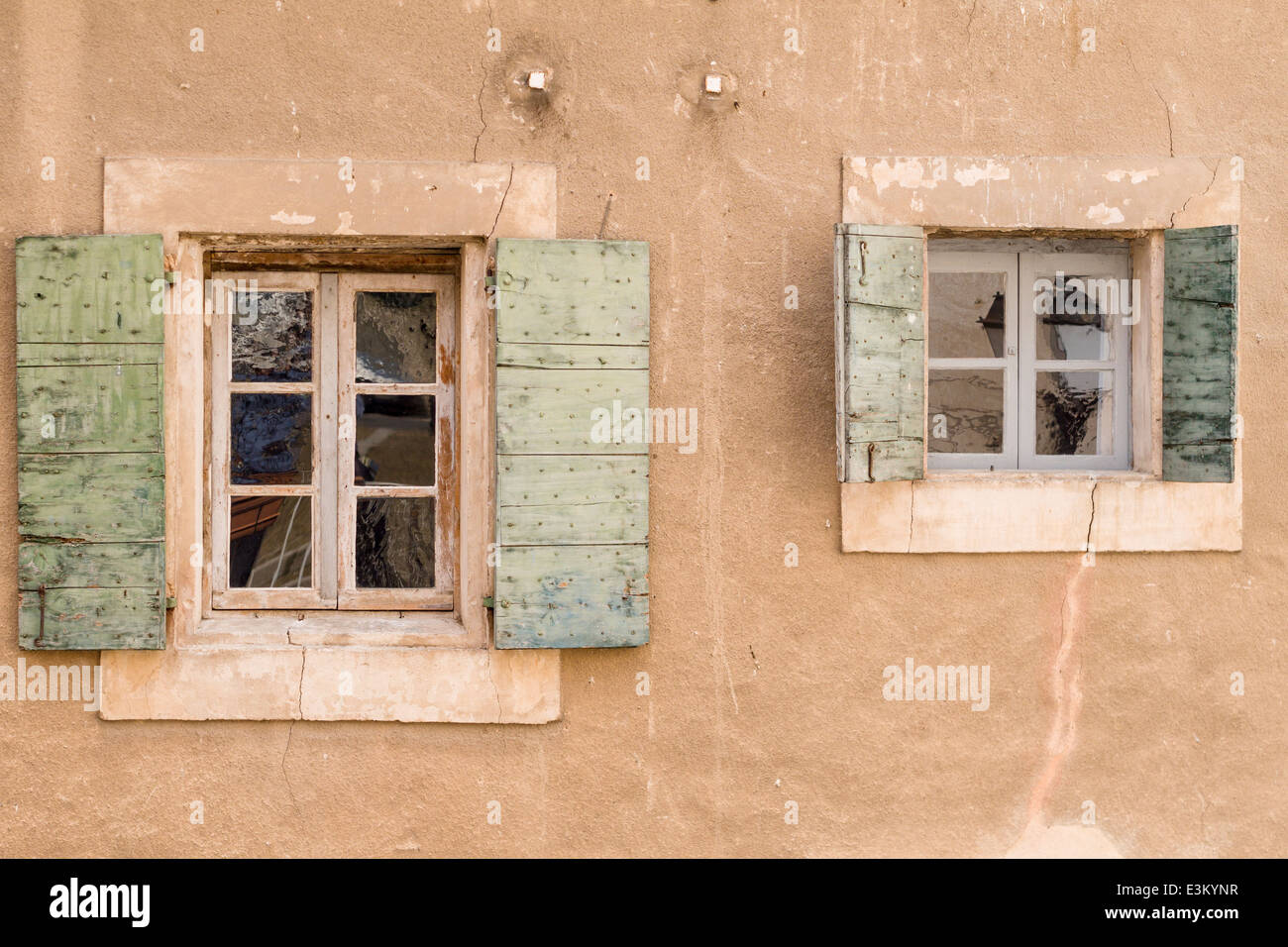 Fenêtres à volets verts. Une paire de windows une petite sur un mur en stuc avec des volets verts chaque ouvert. Banque D'Images