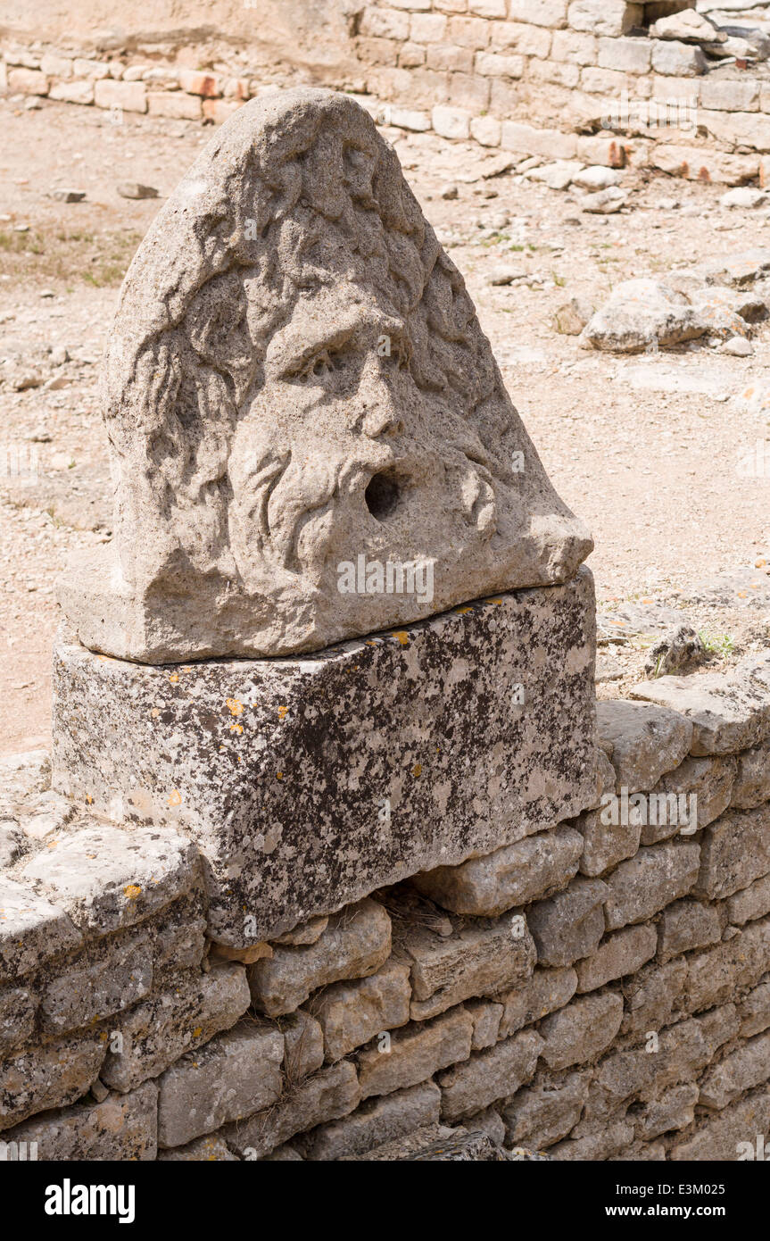 Sauvé de la sculpture les ruines de Glanum. Probablement un ornement bâtiment tombé le visage d'un homme, désormais placé sur un mur. Banque D'Images