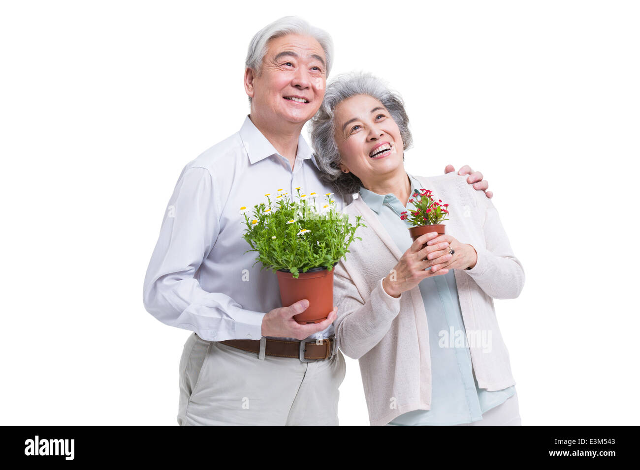 Happy senior couple with potted plants Banque D'Images